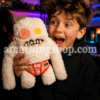 Niño de 9 años sujetando muñeco Fuggler blanco raro y divertido con marca de agua amathingshop.com