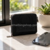 Monedero Desigual Bubbles Marisa Wallet S Black negro sobre mesa con móvil, planta y fondo luminoso