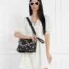 Mujer llevando bolso Desigual Splatter Dortmund Maxi negro con lunares blancos y cadena metálica en look elegante casual