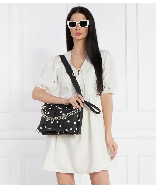 Mujer llevando bolso Desigual Splatter Dortmund Maxi negro con lunares blancos y cadena metálica en look elegante casual