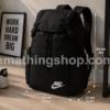 Mochila Nike Heritage negra BA6150-010 original colocada en el suelo mostrando su tamaño real aproximado de 43 cm junto a mobiliario moderno para apreciar sus proporciones