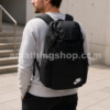 Hombre adulto llevando la mochila Nike Heritage negra BA6150-010 original en un entorno urbano moderno