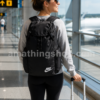 Mujer de viaje utilizando la mochila Nike Heritage negra BA6150-010 original en un aeropuerto con maleta de cabina