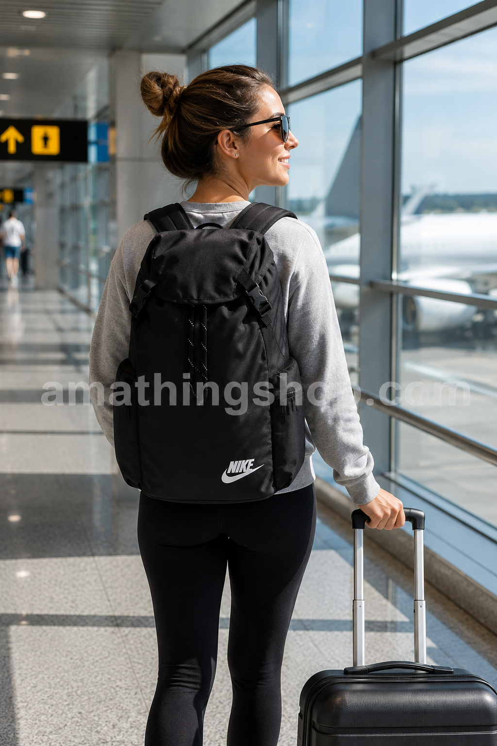 Mujer de viaje utilizando la mochila Nike Heritage negra BA6150-010 original en un aeropuerto con maleta de cabina