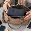 Cartera Desigual Alessia Mariona azul marino de mujer guardándose dentro de un bolso