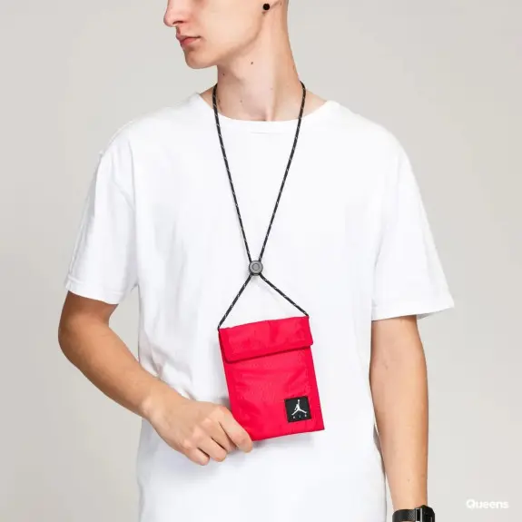 Hombre utilizando mini bandolera Jordan Air Tri Fold roja para móvil, documentación y tarjetas