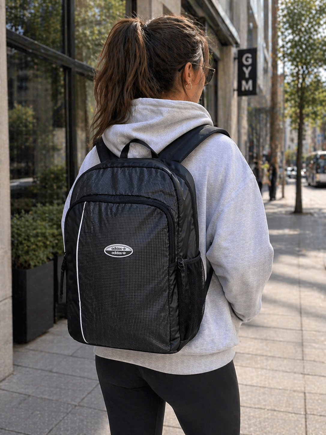 mochila adidas negra gris en uso mujer caminando por ciudad con mochila grande para trabajo y gym
