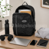 Mochila Adidas Originals RYV negra 29L abierta sobre escritorio con portátil, libreta, botella, auriculares, móvil y sudadera, ideal para universidad, trabajo, gimnasio y uso diario.