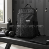 Mochila Adidas Originals RYV negra 29L en vestuario de gimnasio con botella, auriculares, toalla y ropa deportiva, ideal para gym, trabajo, universidad y uso diario.
