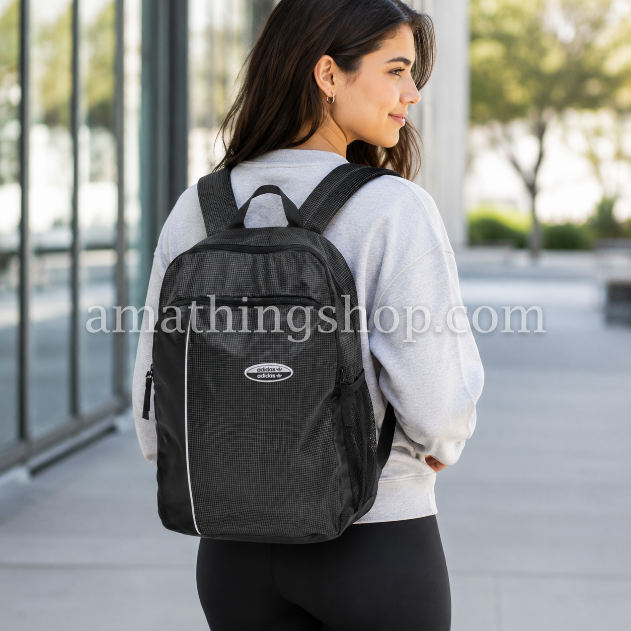 Mochila Adidas Originals RYV negra 29L puesta por una mujer en entorno urbano, ideal para universidad, trabajo, gimnasio, viajes cortos y uso diario con estilo cómodo y deportivo.
