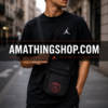 Hombre usando bandolera Jordan PSG negra estilo urbano en calle europea con look streetwear moderno.