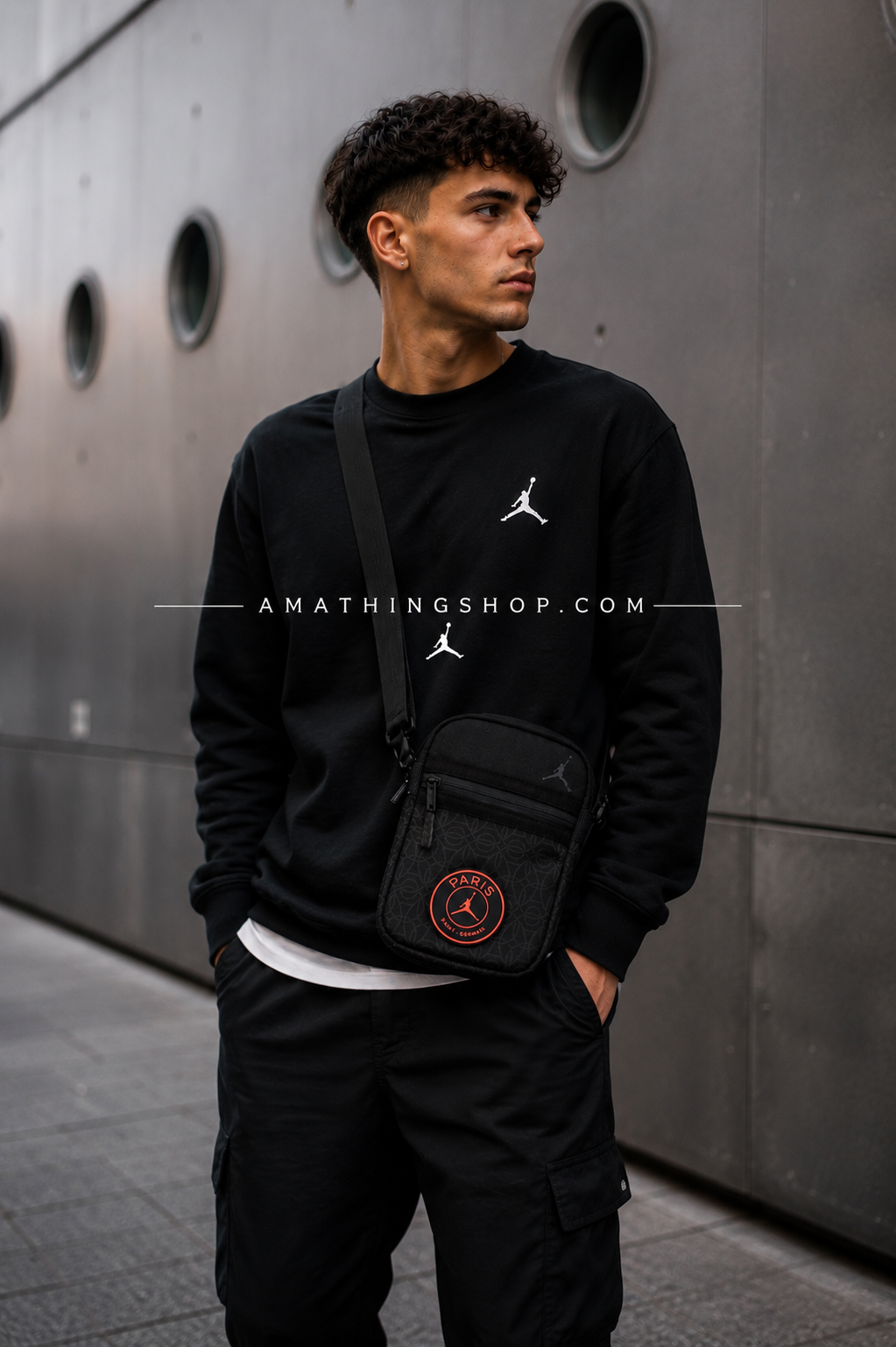 Hombre usando bandolera Jordan PSG negra estilo urbano moderno en escenario europeo minimalista.