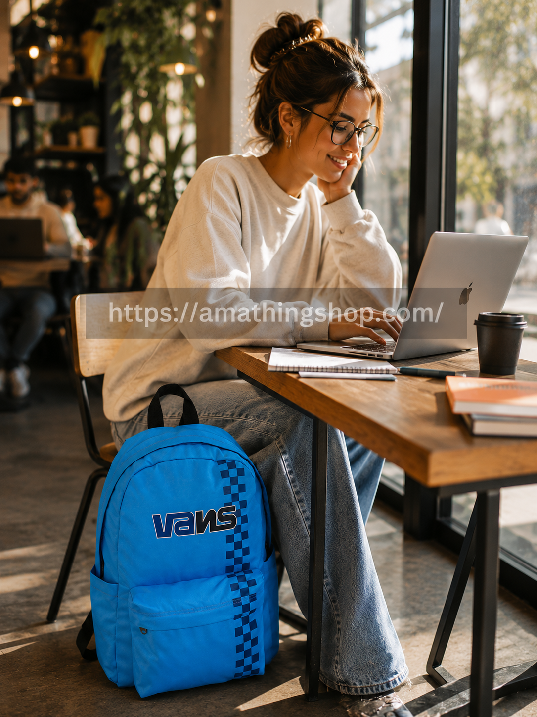 Mochila portátil Vans azul utilizada en cafetería moderna con portátil y estilo urbano cómodo para universidad y trabajo