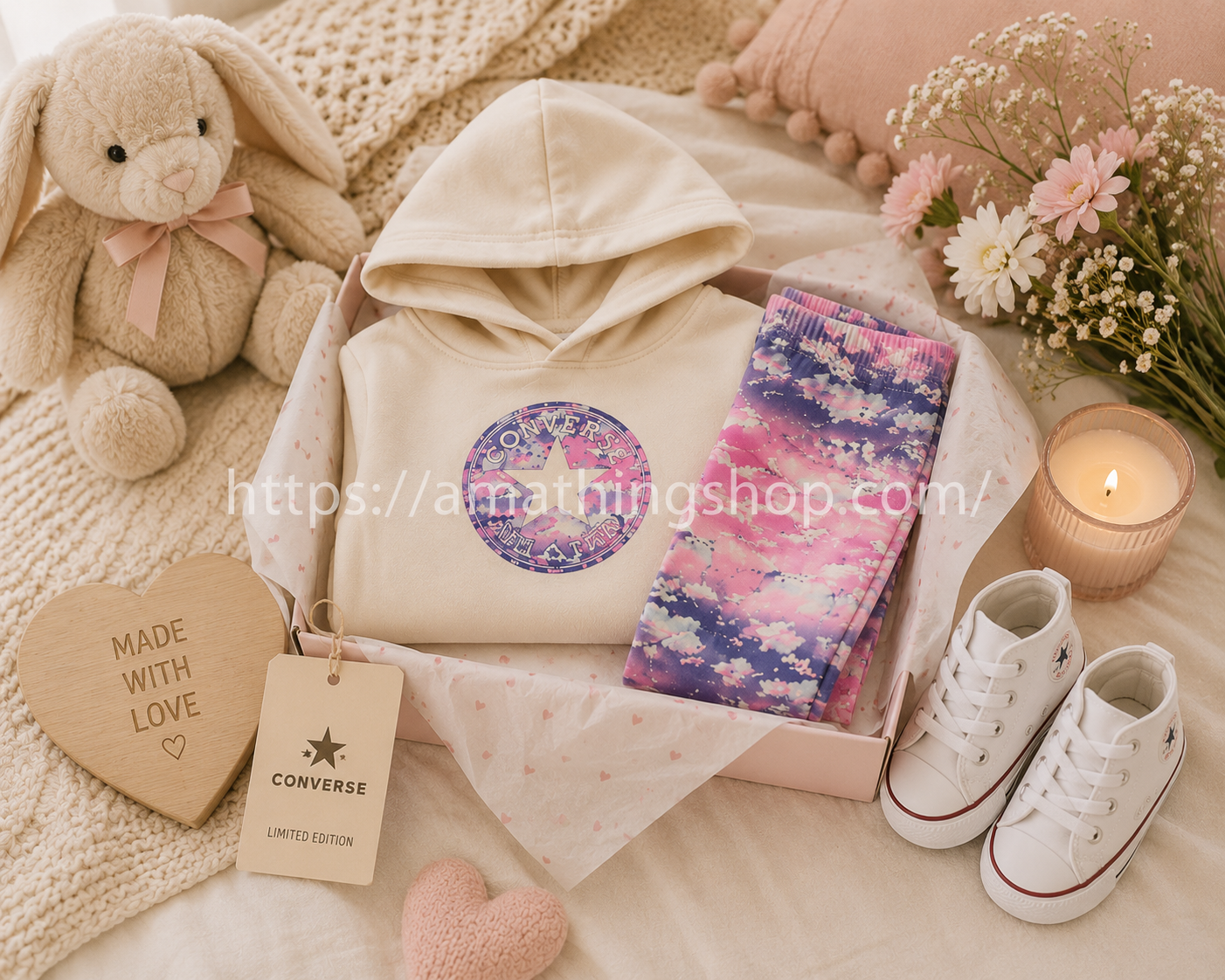 Conjunto Converse bebé niña beige y rosa presentado como regalo premium sobre cama infantil elegante