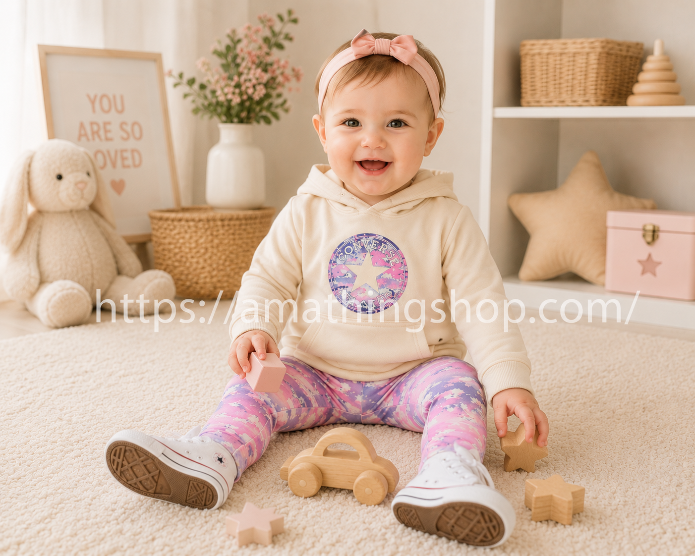 Bebé niña sentada jugando con conjunto Converse beige y leggings rosa en habitación premium luminosa