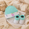 Conjunto Converse bebé turquesa arcoíris presentado como regalo premium para recién nacido