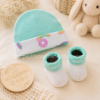 Conjunto Converse bebé turquesa con gorro arcoíris y patucos suaves presentado como regalo premium