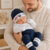 Padre con bebé recién nacido llevando conjunto Converse azul marino Padre sosteniendo a su bebé recién nacido con conjunto Converse azul marino de gorro y patucos para 0 a 6 meses.