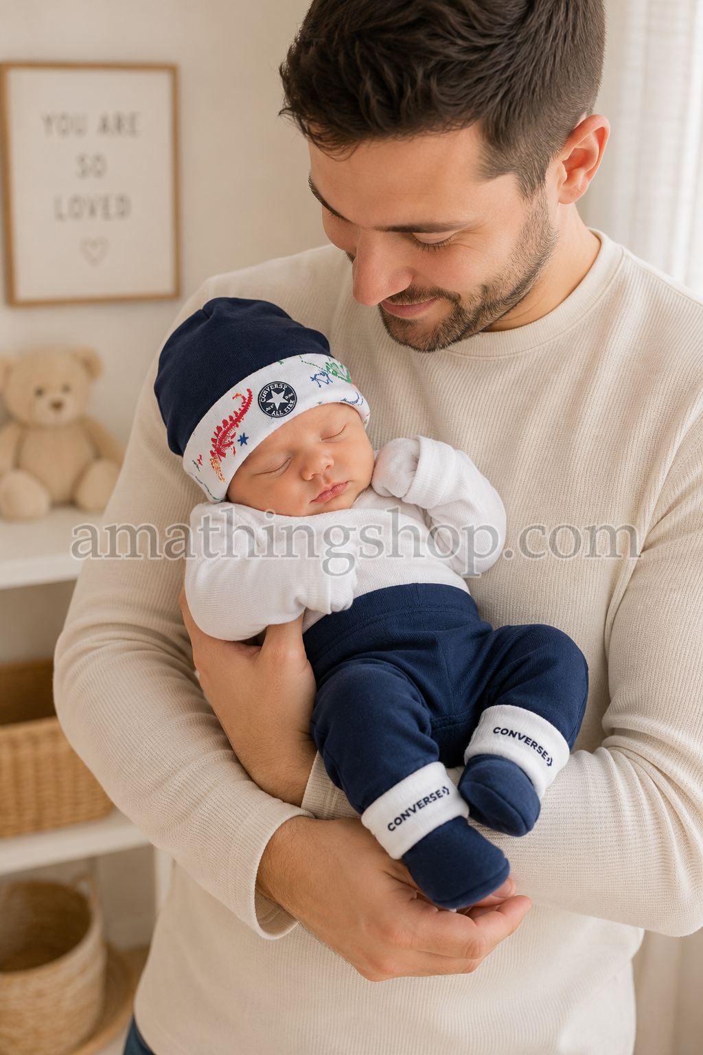Padre con bebé recién nacido llevando conjunto Converse azul marino Padre sosteniendo a su bebé recién nacido con conjunto Converse azul marino de gorro y patucos para 0 a 6 meses.