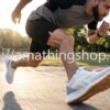 Hombre corriendo en un parque al atardecer usando las zapatillas Reebok Lite Plus 2.0 blancas con suela de goma. Imagen de estilo de vida que destaca la ligereza y amortiguación EVA de este modelo de running talla 44. Disponible en amathingshop.com.