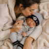 Madre abrazando bebé recién nacido con gorro y calcetines Converse gris negro premium