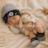 Bebé dormido usando gorro y calcetines Converse gris negro estilo urbano premium