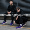 Dos chicos usando zapatillas adidas NMD_V3 GW3062 moradas estilo urbano streetwear moderno.