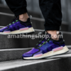 Primer plano de zapatillas adidas NMD_V3 GW3062 moradas en escaleras urbanas estilo streetwear moderno.