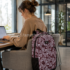 Mujer trabajando con mochila Vans Disorder 24 litros granate para portátil en oficina moderna