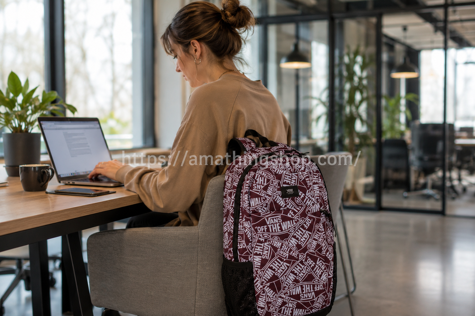 Mujer trabajando con mochila Vans Disorder 24 litros granate para portátil en oficina moderna