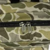 Detalle de cremalleras Vans y bolsillo frontal de la mochila Vans Old Skool Grom camuflaje verde 18L, práctica para colegio, instituto, accesorios, llaves, móvil y uso diario.