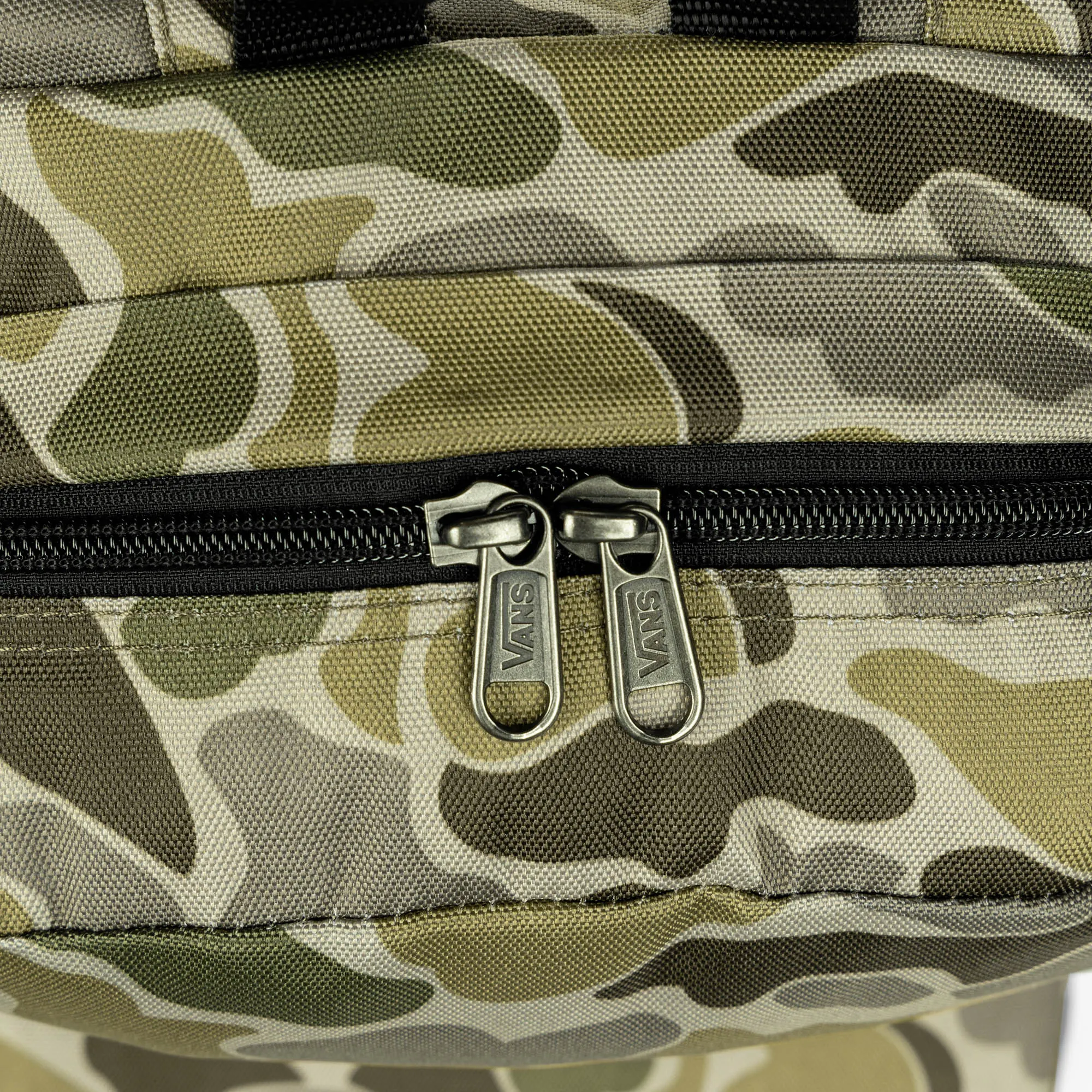 Detalle de cremalleras Vans y bolsillo frontal de la mochila Vans Old Skool Grom camuflaje verde 18L, práctica para colegio, instituto, accesorios, llaves, móvil y uso diario.