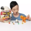 Niño jugando con Smashers Dino Island Huevo Gigante Epic, dinosaurio naranja montado, mini figuras, huevo sorpresa y accesorios sobre una mesa. Imagen de uso real del juguete de dinosaurios con más de 25 sorpresas, ideal como regalo para niños desde 5 años, cumpleaños, Navidad o Reyes.