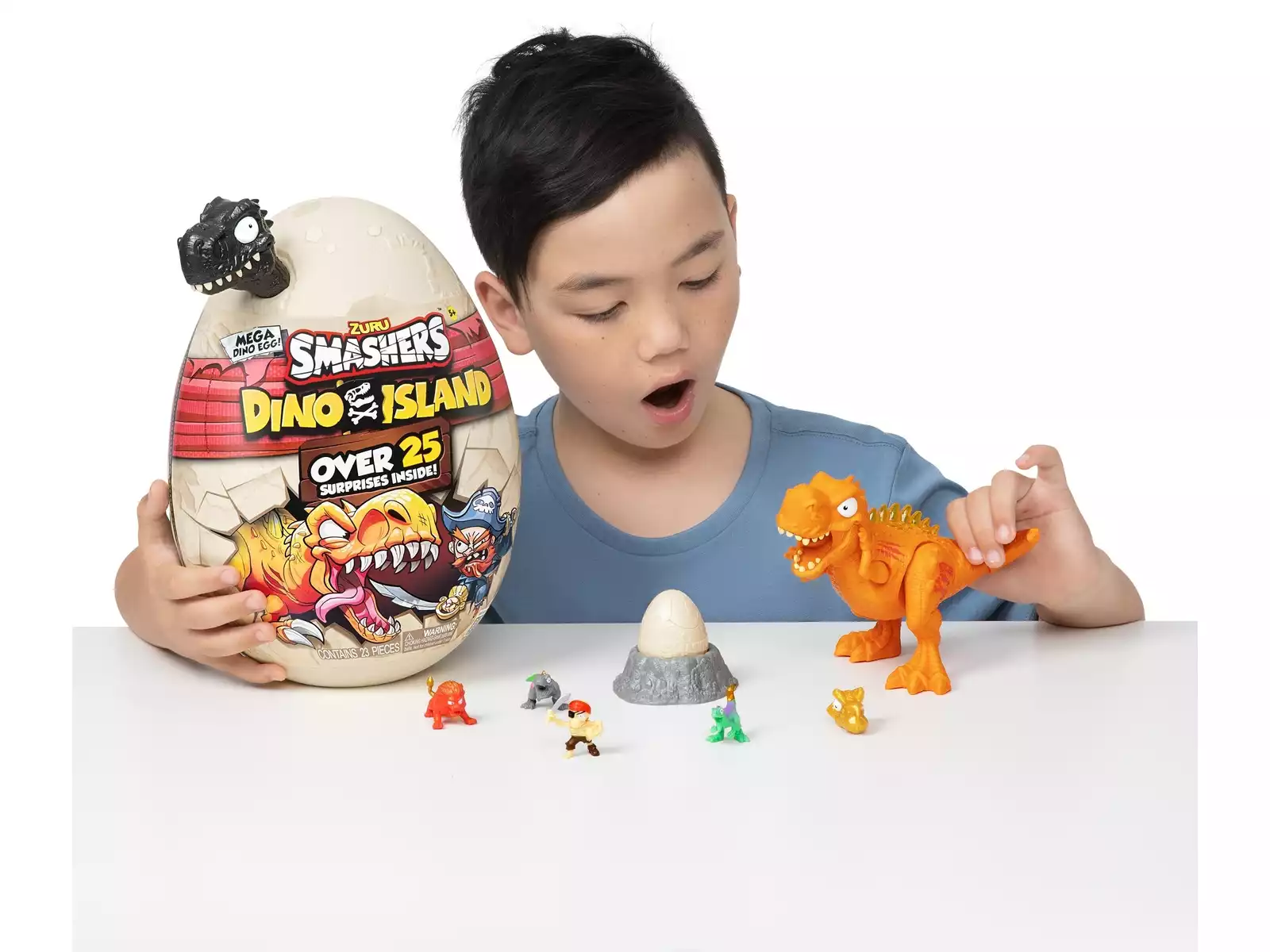 Niño jugando con Smashers Dino Island Huevo Gigante Epic, dinosaurio naranja montado, mini figuras, huevo sorpresa y accesorios sobre una mesa. Imagen de uso real del juguete de dinosaurios con más de 25 sorpresas, ideal como regalo para niños desde 5 años, cumpleaños, Navidad o Reyes.