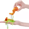 Smashers Dino Island Huevo Gigante Epic con slime verde elástico y piezas de dinosaurio naranja en las manos. Detalle del juguete de dinosaurios con slime para descubrir piezas, montar el dinosaurio y jugar sin pantallas desde 5 años.