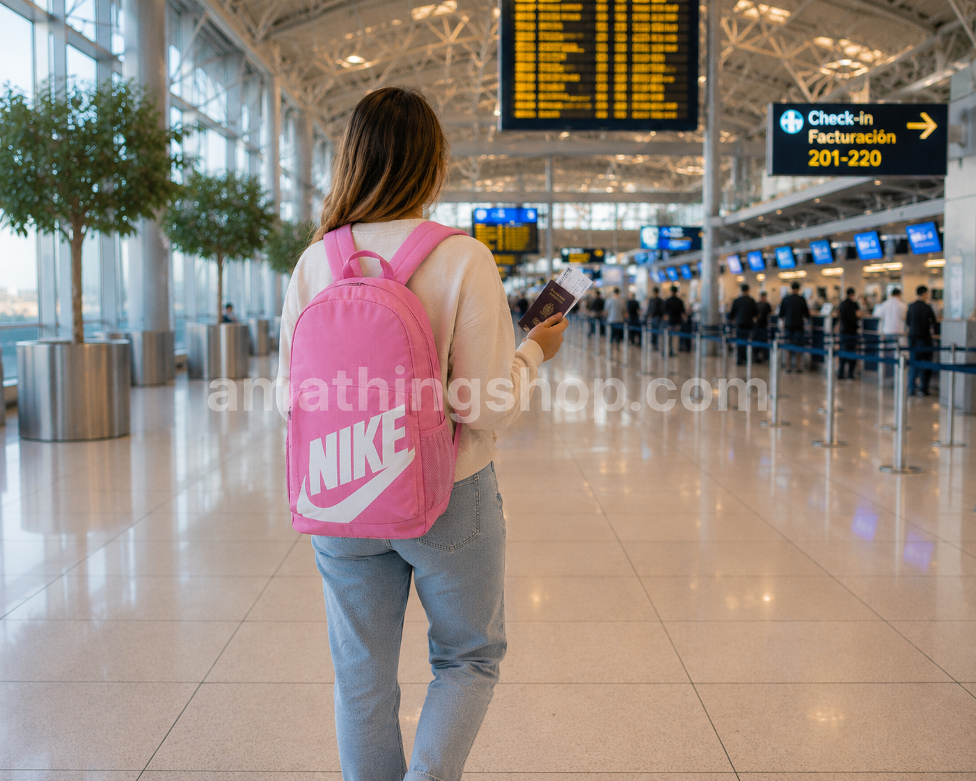Mujer de 30 años viajando con mochila Nike Elemental rosa DR6084-646 en un aeropuerto moderno