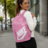 Mujer de 35 años usando la mochila Nike Elemental rosa DR6084-646 sin estuche en un entorno urbano