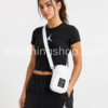 Mujer llevando bolso bandolera Nike Air Jordan Crossbody blanco original con estilo urbano y deportivo