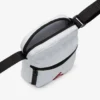 Bandolera Jordan blanca abierta con compartimento principal de cremallera