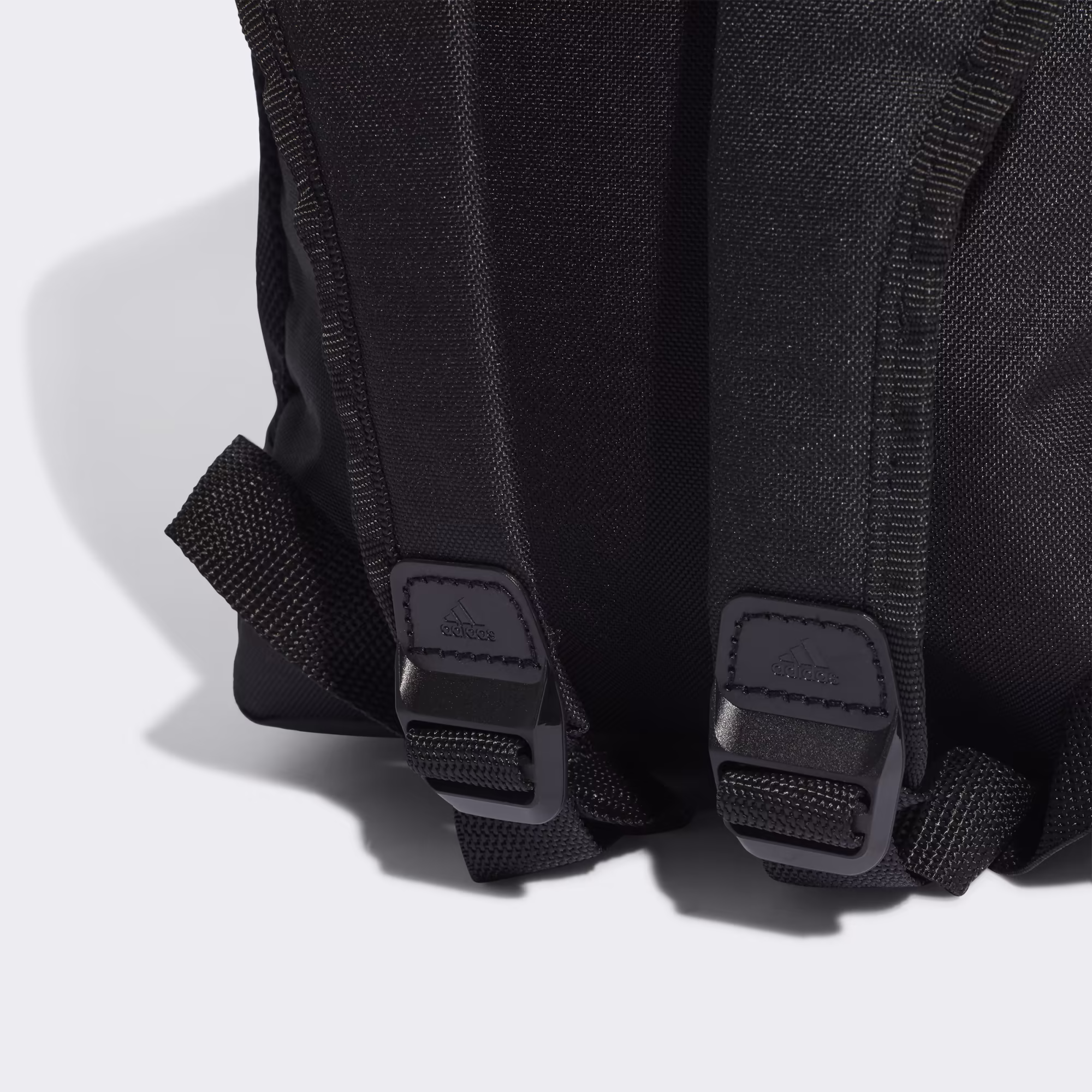 Detalle de la base reforzada resistente al desgaste de la mochila adidas Linear Essentials negra.
