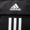 Mochila Adidas Power JZ2308 negra junto a una toalla, botella y zapatillas deportivas en un gimnasio