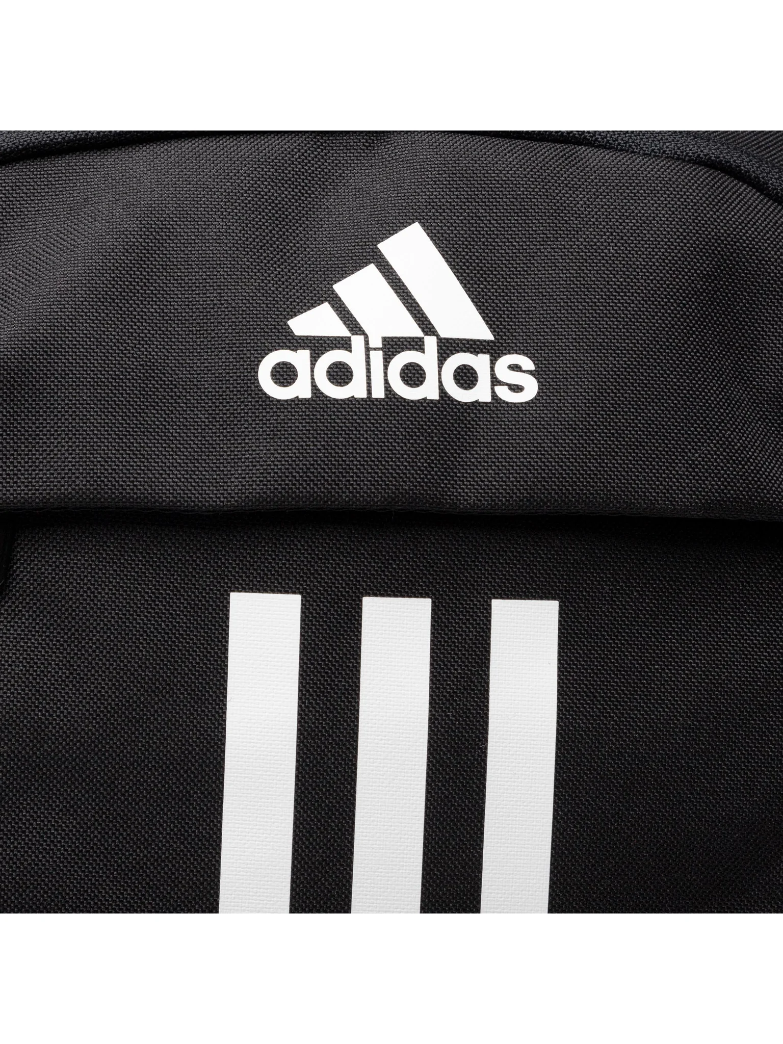 Mochila Adidas Power JZ2308 negra junto a una toalla, botella y zapatillas deportivas en un gimnasio