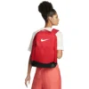Mujer llevando mochila Nike Brasilia 9.5 roja de 24 litros a la espalda