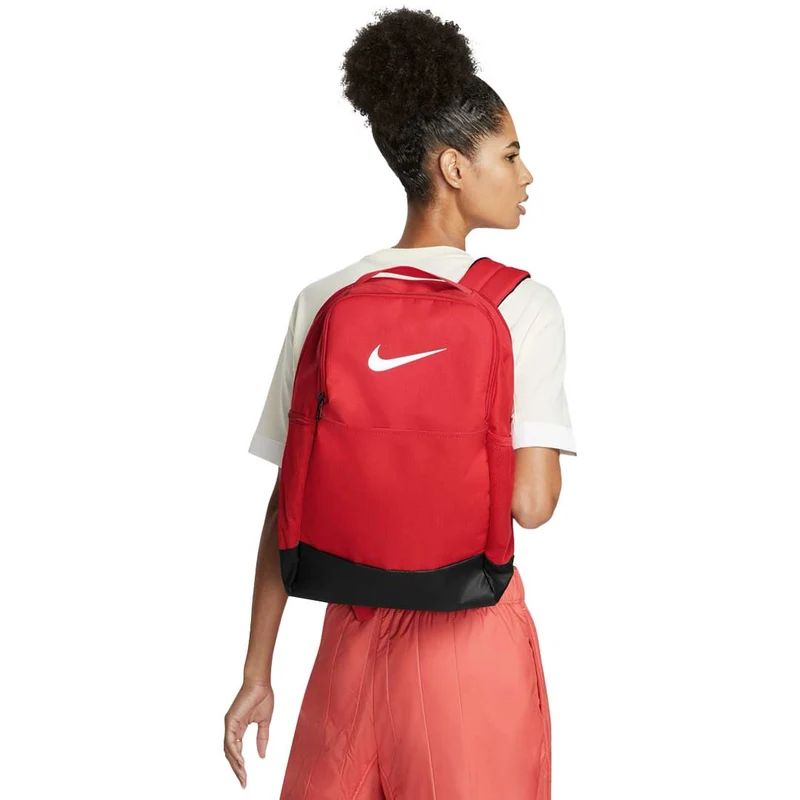 Mujer llevando mochila Nike Brasilia 9.5 roja de 24 litros a la espalda