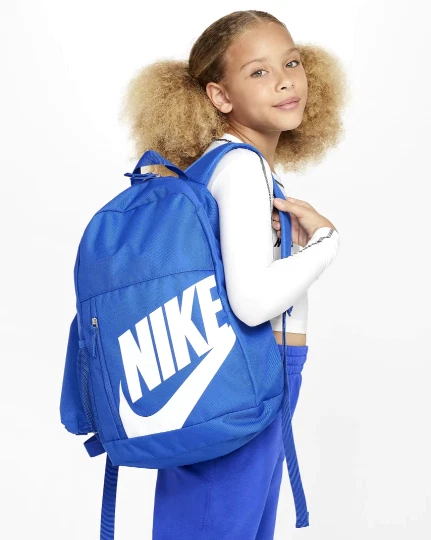 Mochila Nike Elemental 20L azul llevada a la espalda en contexto juvenil
