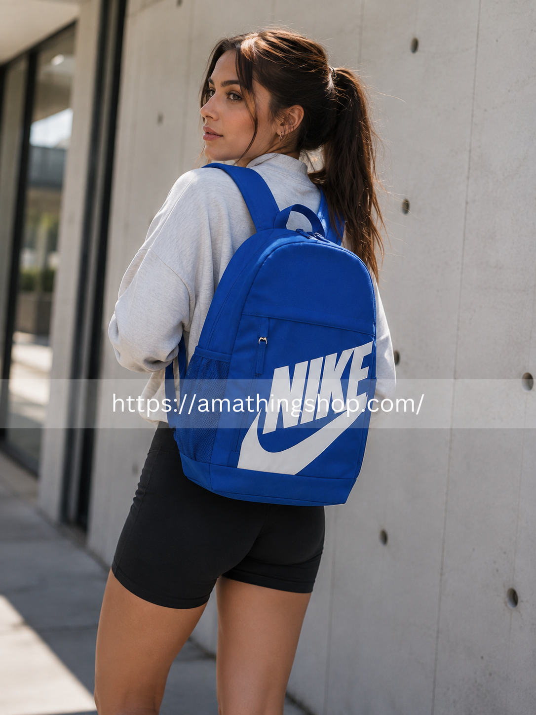 Mujer joven llevando mochila Nike Elemental 20L azul DR6084-480 a la espalda