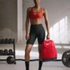 Mochila de entrenamiento Nike Brasilia 9.5 24L roja junto a deportista
