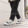 Hombre con pantalones negros caminando con Nike Air Alpha Force 88 en blanco roto, negro y verde.