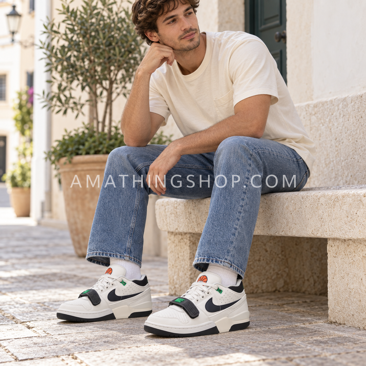 Hombre con vaqueros y camiseta clara usando Nike Air Alpha Force 88 en blanco roto, negro y verde.
