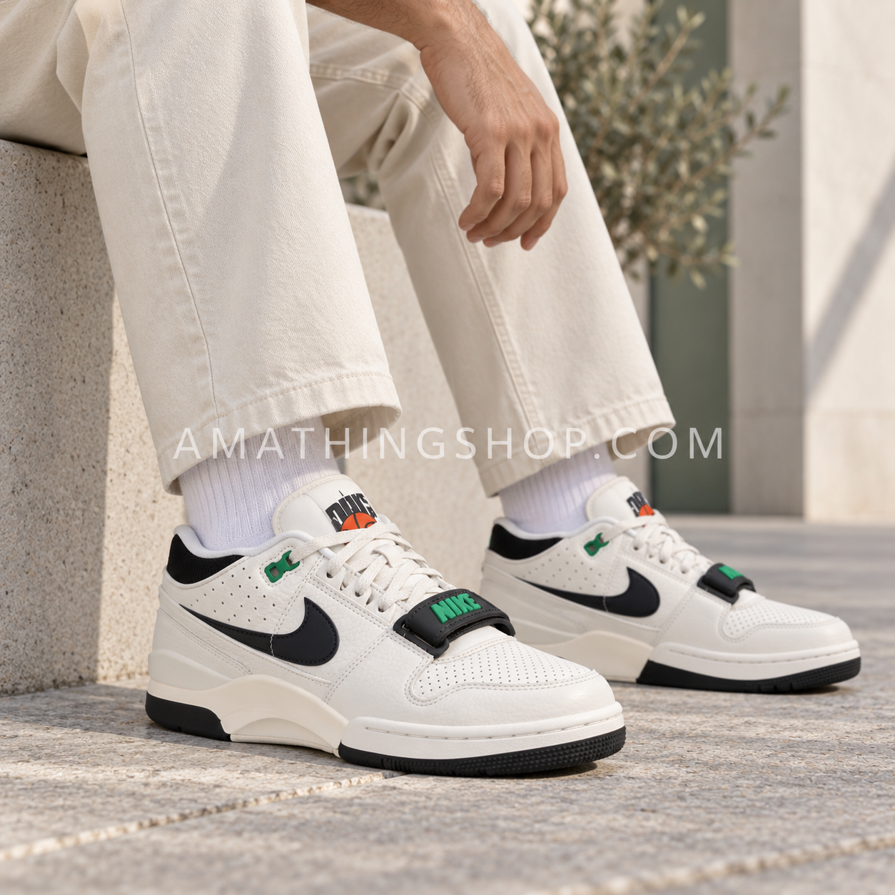 Primer plano de un hombre con pantalón crema y Nike Air Alpha Force 88 blancas con detalles negros y verdes.